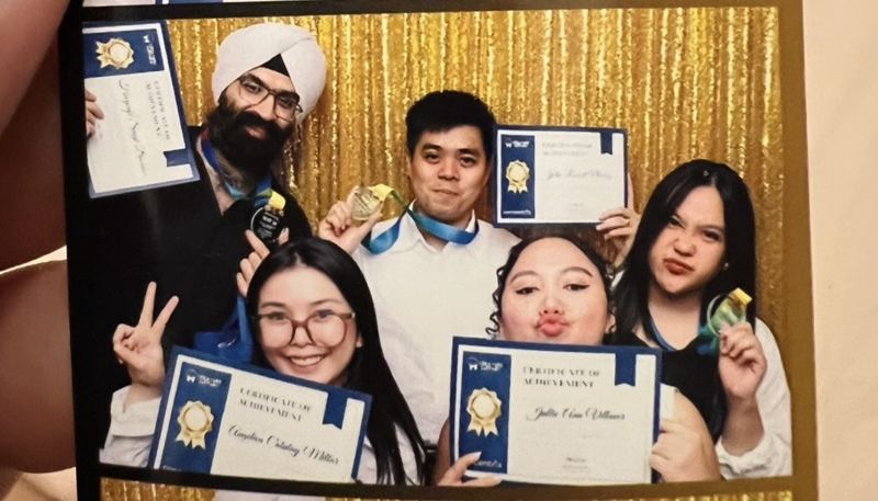 Photobooth strip of Angelica in glasses, bottom left, holding her Certificate of Achievement beside four colleagues with their certificates and medals